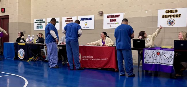 Extension educator at a resource fair, speaking with incarcerated fathers. 