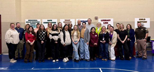 A group of people in a large gym during a resource fair for incarcerated people. 